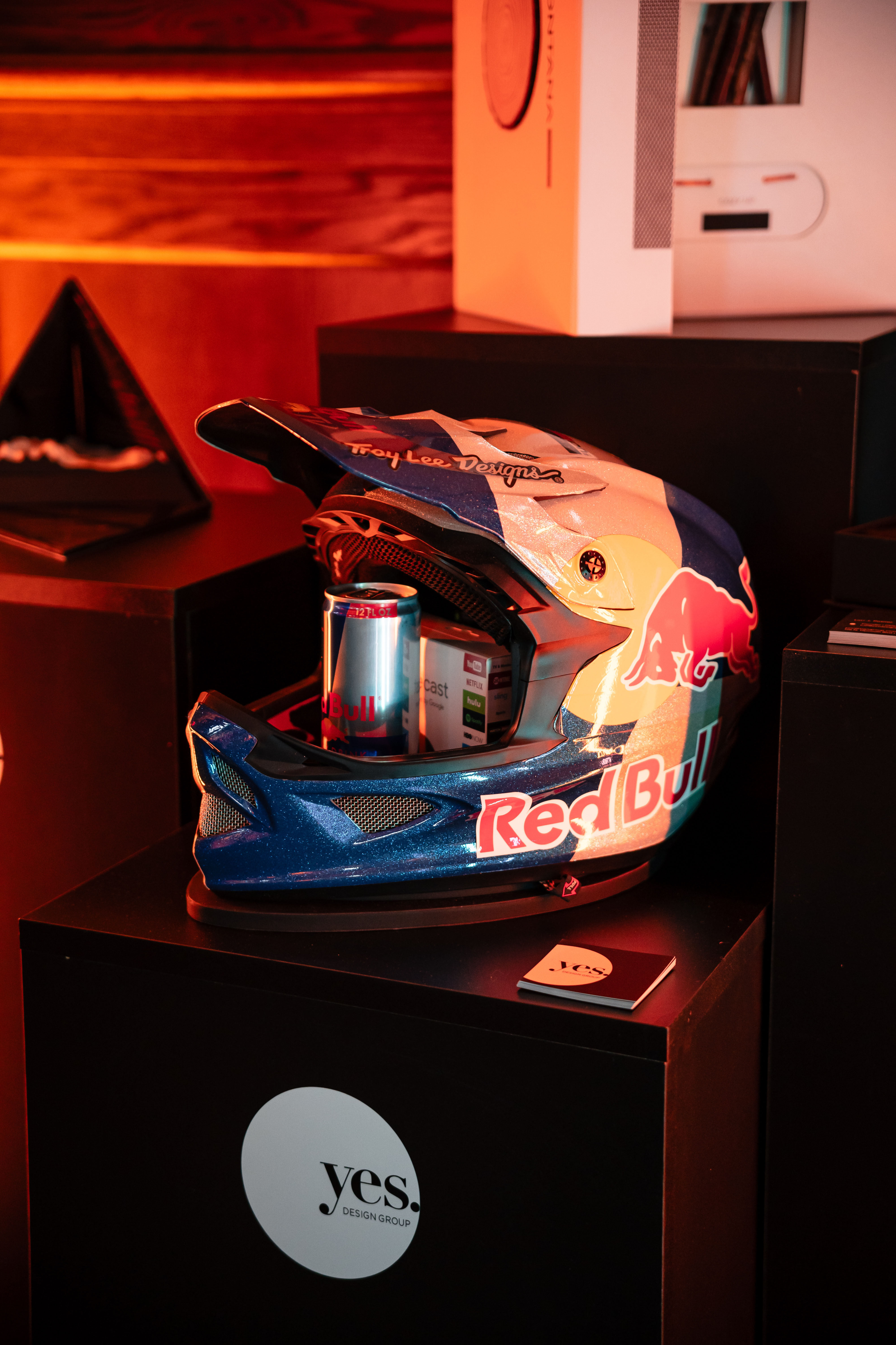 A red bull branded full face helmet and drink on a podium